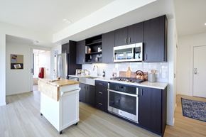 Portland apartment for rent - Kitchen with stainless steel appliances and dark cabinets at Grand Belmont Apartments in Central Eastside Portland, Oregon.