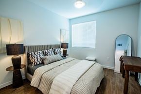Henderson apartment for rent - A bedroom with a large bed and a wooden table.