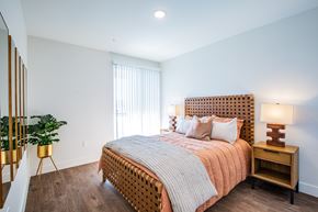 North Las Vegas apartment for rent - A bedroom with a bed, nightstand, and a potted plant.