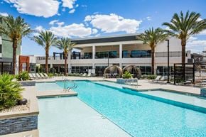 Henderson apartment for rent - A swimming pool in front of a building with palm trees.