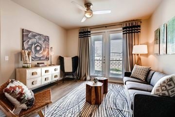 Kyle apartment for rent - A living room with a couch, chair, and a painting on the wall.