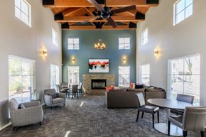 Tucson apartment for rent - A spacious living room with a fireplace and a ceiling fan.