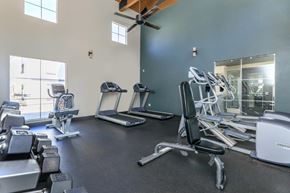 Tucson apartment for rent - A gym with a variety of equipment including treadmills, weights, and a fan.
