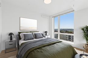 Seattle apartment for rent - A bedroom with a large bed and a view of the city.