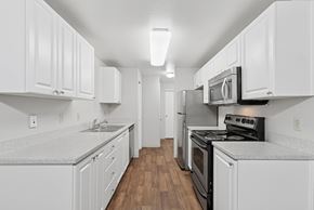Everett apartment for rent - A kitchen with white cabinets and black appliances.