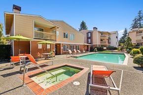 Everett apartment for rent - A large house with a pool and patio furniture.