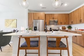 Austin apartment for rent - A modern kitchen with wooden cabinets and a white island.