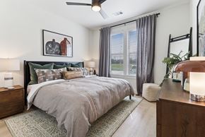 Austin apartment for rent - A bedroom with a large bed and a ceiling fan.