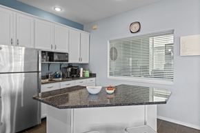 Spokane Valley apartment for rent - a kitchen with a granite counter top and a stainless steel refrigerator
