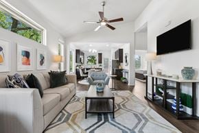 Austin apartment for rent - A living room with a beige couch, a coffee table, and a ceiling fan.