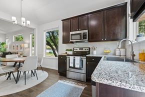 Austin apartment for rent - A modern kitchen with dark brown cabinets and a granite countertop.