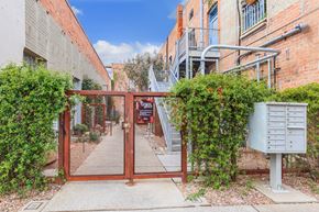 Tucson apartment for rent - A gate with a mailbox on the side of a brick building.