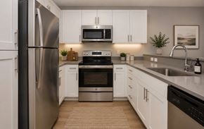 Richland apartment for rent - A modern kitchen with white cabinets and stainless steel appliances.