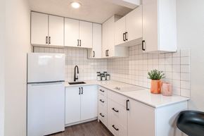 Spokane apartment for rent - a kitchen with white cabinets and a white refrigerator