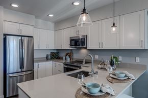 Bellevue apartment for rent - Lux Apartments Bellevue kitchen with arctic white cabinet finishes, undermount sink and quartz countertops and stainless-steel appliances, including overhead microwave, double-door refrigerator, and f