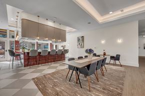 Pflugerville apartment for rent - A dining room with a checkered floor and a long table with chairs.