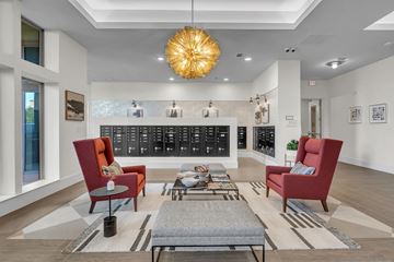 Pflugerville apartment for rent - A modern living room with a red chair and a grey coffee table.