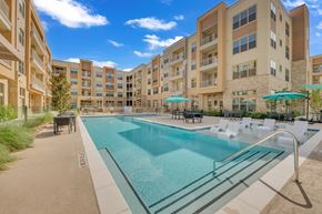 Pflugerville apartment for rent - A large swimming pool in front of apartment buildings.