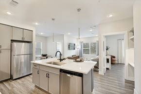 Spring apartment for rent - A modern kitchen with a stainless steel refrigerator and a white countertop.