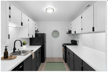 Vancouver apartment for rent - A modern kitchen with black cabinets and white countertops.