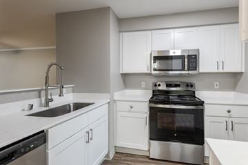 Issaquah apartment for rent - A modern kitchen with a stainless steel oven and white cabinets.