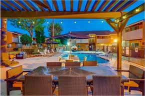 Covina apartment for rent - A poolside area with a table and chairs under a canopy.