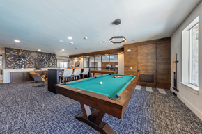Austin apartment for rent - A pool table is in the middle of a room with a patterned carpet.