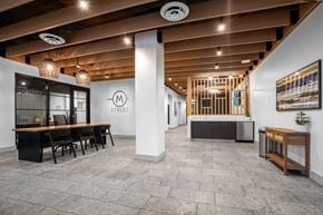 Seattle apartment for rent - A conference room with a long table and chairs, a white wall with a logo, and a wooden cabinet.
