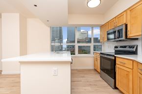 Seattle apartment for rent - A kitchen with wooden cabinets and a white island.