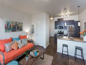 Great Falls apartment for rent - a living room with an orange couch and a kitchen