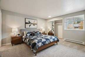 Gresham apartment for rent - A bedroom with a large bed and a window showing trees outside.