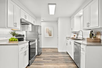 Bend apartment for rent - A modern kitchen with white cabinets and stainless steel appliances.