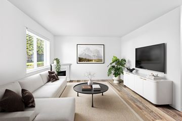 Bend apartment for rent - A living room with a white couch, a coffee table, and a painting on the wall.
