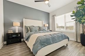 Spring apartment for rent - A bedroom with a large bed and a ceiling fan.