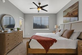 Tucson apartment for rent - A bedroom with a bed, dresser, and ceiling fan.