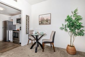 Tucson apartment for rent - A dining area with a table and chairs and a potted plant.