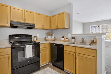Jessup apartment for rent - A kitchen with wooden cabinets and a black stove top oven.