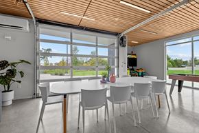 Spokane apartment for rent - a dining room with white tables and chairs and large windows