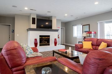 Gretna apartment for rent - A living room with red leather couches and a fireplace.