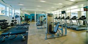 Bluffdale apartment for rent - A gym with a variety of equipment including treadmills, weights, and exercise machines.