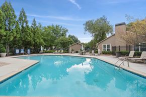 Austell apartment for rent - A large swimming pool surrounded by trees and chairs.