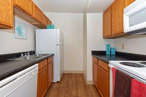 Tucson apartment for rent - A kitchen with wooden cabinets and a white fridge.