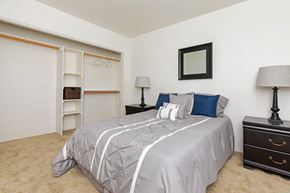 Tucson apartment for rent - A bedroom with a bed, dresser, and a mirror on the wall.
