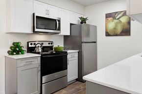 Phoenix apartment for rent - A modern kitchen with white cabinets and stainless steel appliances.