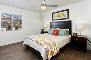 Phoenix apartment for rent - A bedroom with a bed, nightstand, and a painting on the wall.