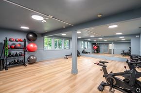 Renton apartment for rent - A gym with a variety of exercise equipment and a mirror on the wall.