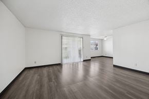 Kennewick apartment for rent - A room with a sliding glass door and wooden flooring.