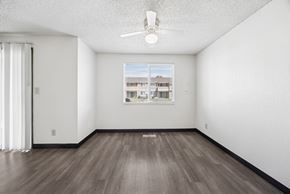 Kennewick apartment for rent - A room with a ceiling fan and a window showing a building outside.