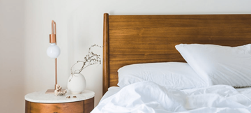 Garland apartment for rent - A bed with white pillows and a white bedspread is next to a wooden headboard.