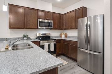 Flagstaff apartment for rent - A modern kitchen with a stainless steel refrigerator and wooden cabinets.